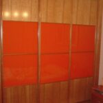 Frente de armario combinando cristal lacado naranja y chapa de cerezo