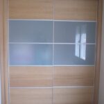 Armario corredero combinando roble con cristal al ácido