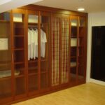 Armario de puertas plegables cristal transparente y perfiles de cerezo