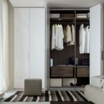 Interior de armario en acabado nogal con módulos de ropa corta y cajoneras