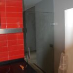 Puerta abatible de cristal templado con montante fijo