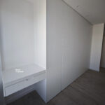 Frente de armario de hojas lisas abatibles lacado blanco con tirador uñero fresado